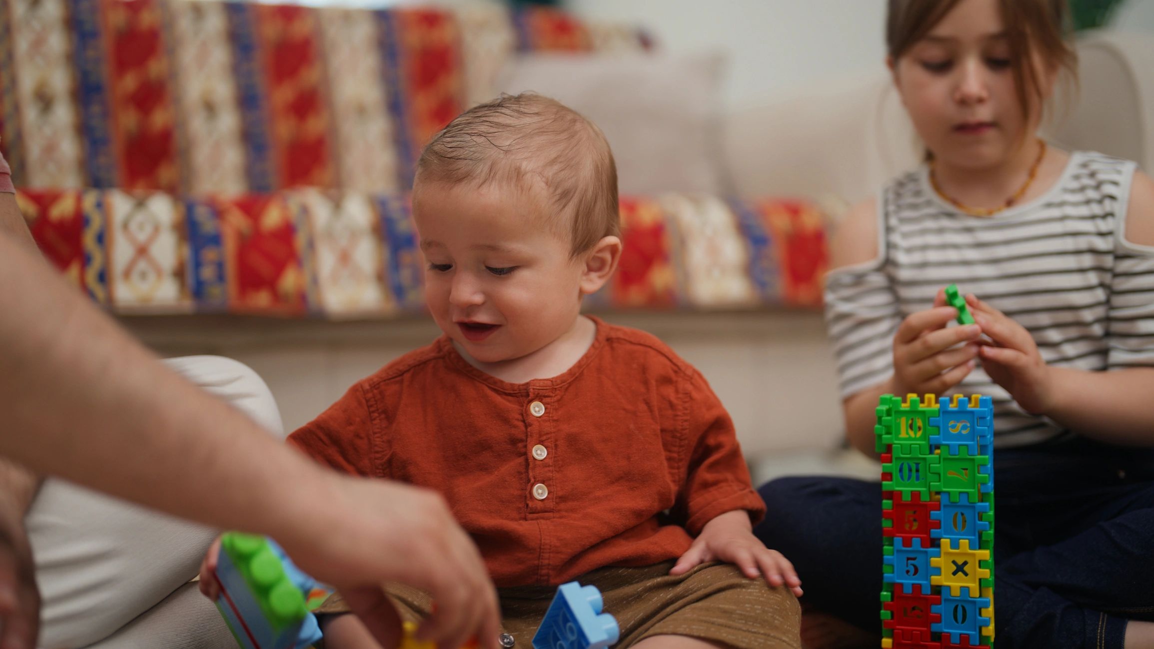 Father playing and entertaining two young children at home