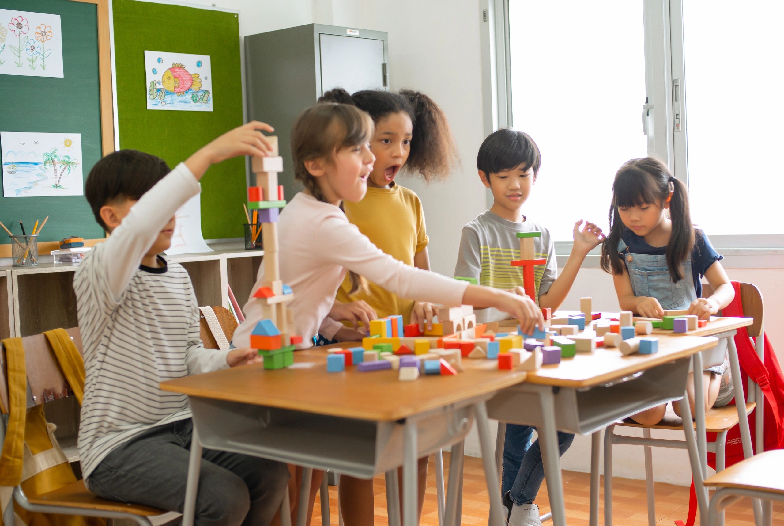Kids playing with colourful blocks in a classroom