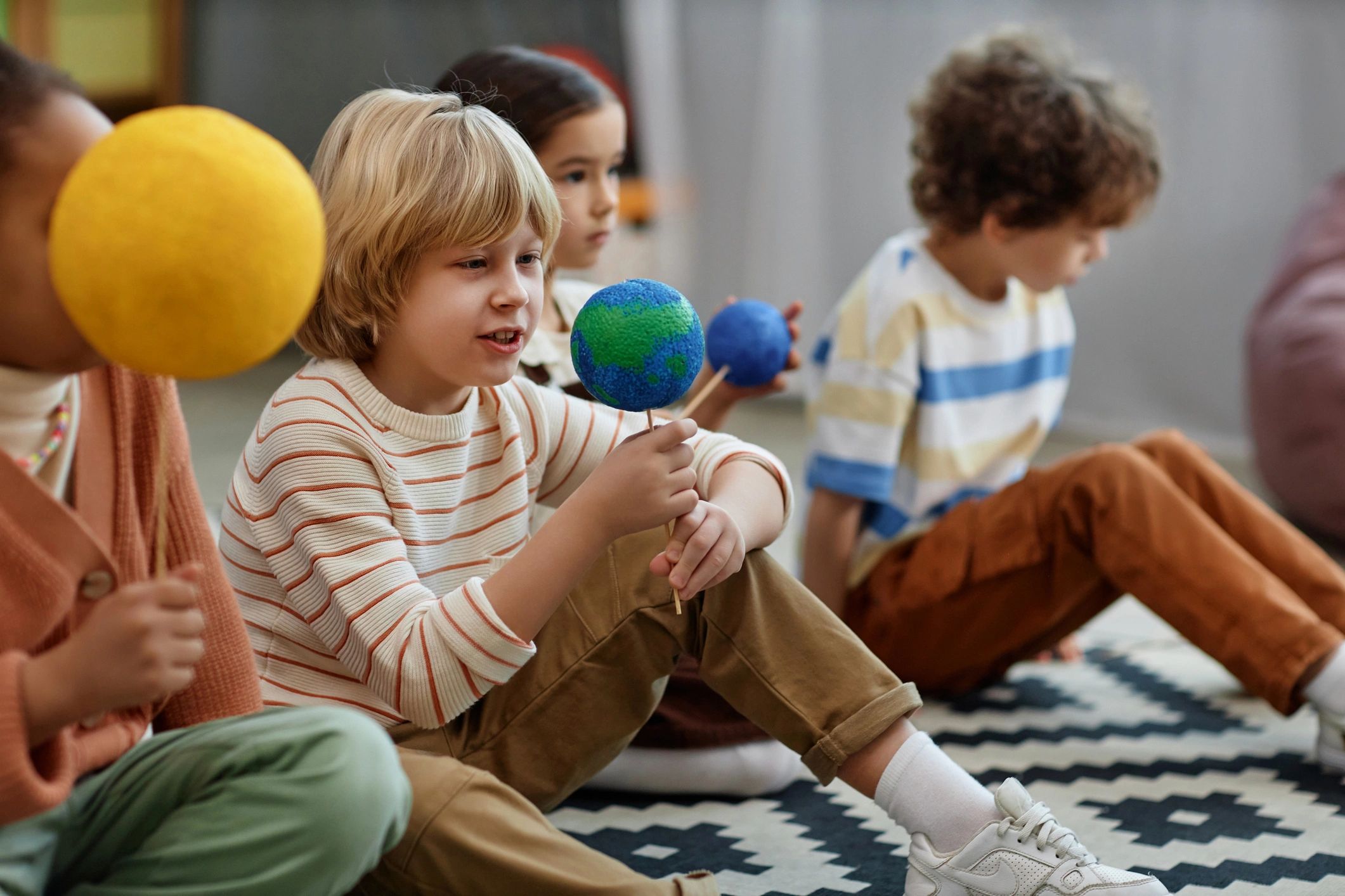 Child holding an Earth model in preschool class