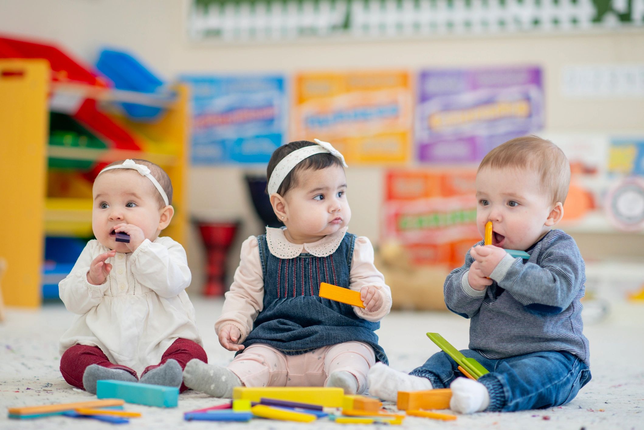 Toddlers playing with colourful blocks in a bright playroom