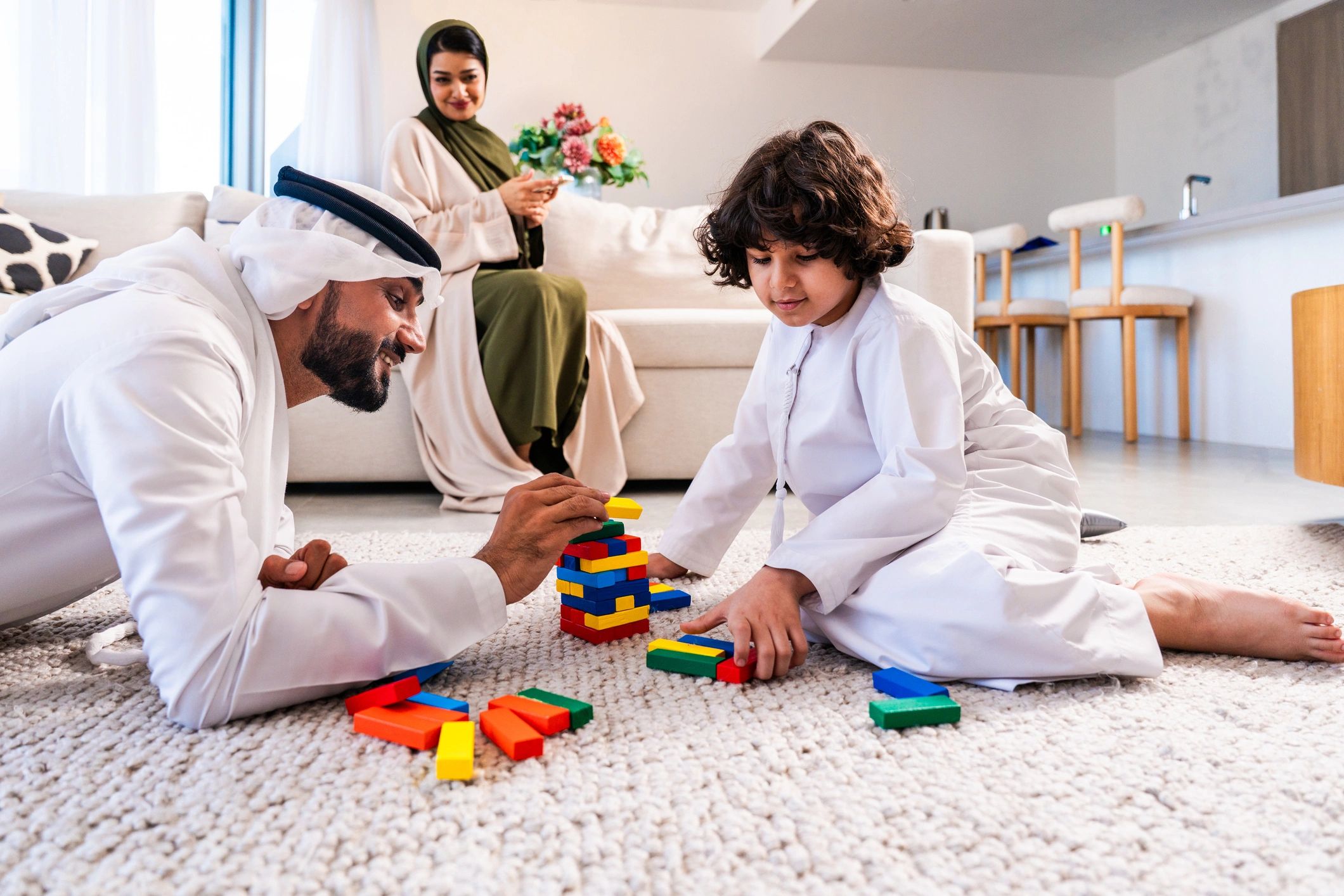 Father and son building a block tower at home