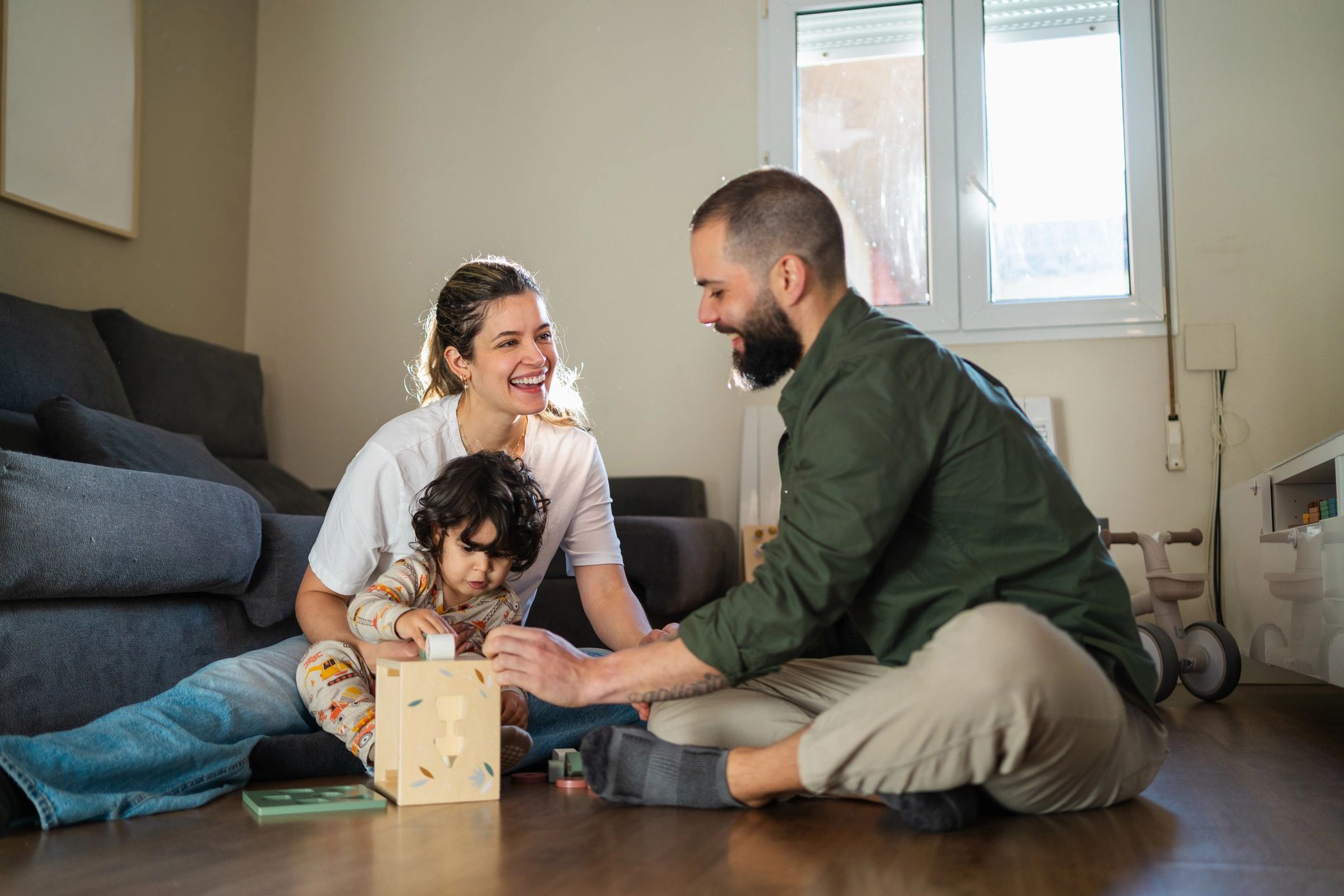 Parents playing with a toddler at home during early learning time